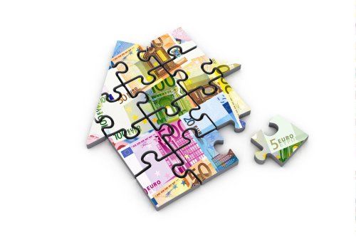 Imagen conceptual de reclamación de gastos hipotecarios en Salamanca, con una casa formada por piezas de puzzle y billetes en euros